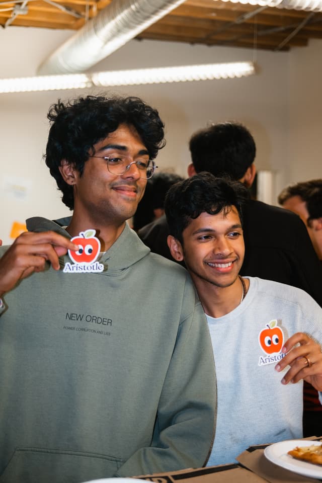 Two fellows holding Aristotle stickers